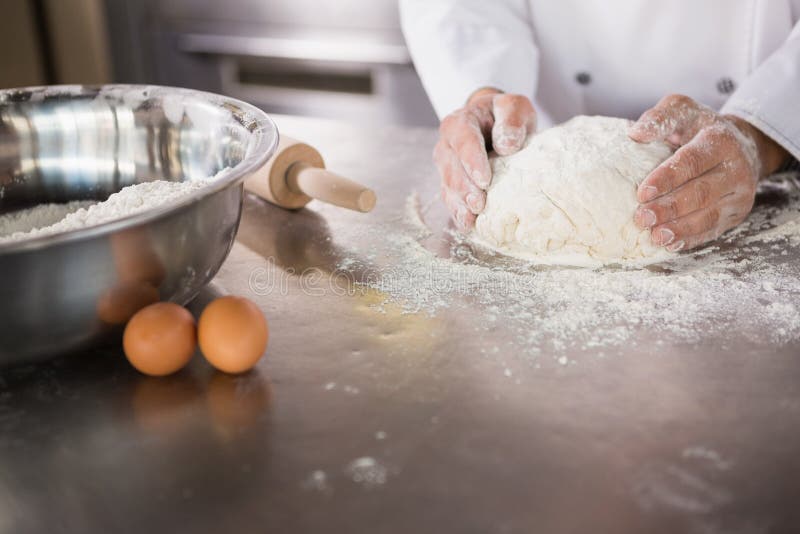 Close up of baker preparing dough in the kitchen of the bakery. Close up of baker preparing dough in the kitchen of the bakery