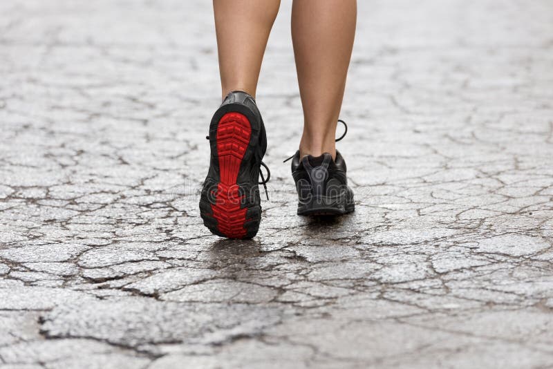 Ciérrese para arriba en los zapatos de gimnasio en la calle de la grieta fotografía de archivo libre de regalías Ciérrese para arriba en los zapatos de gimnasio en la calle de la grieta fotografía de archivo libre de regalías