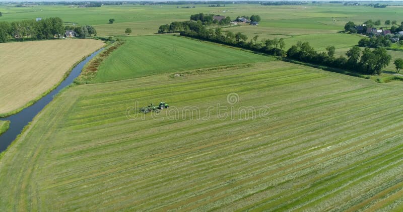 Ciągnik z wirującymi ostrzami na polu w typowych holowniczych płaskich fryzjach krajobrazowych na niderlandach nagranie z dronem 4