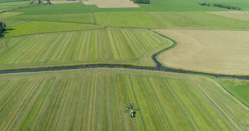 Ciągnik z wirującymi ostrzami na polu w typowych holowniczych płaskich fryzjach krajobrazowych na niderlandach nagranie z dronem 4