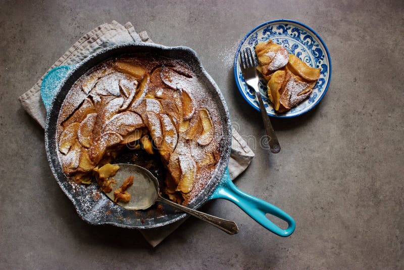 Clafoutis rôtis de pomme (gâteau français de crème anglaise) dans la casserole de fonte photos stock Clafoutis rôtis de pomme (gâteau français de crème anglaise) dans la casserole de fonte photos stock
