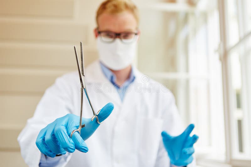 Clamp on hands of surgeon stock photo. Image of gloves 131049830