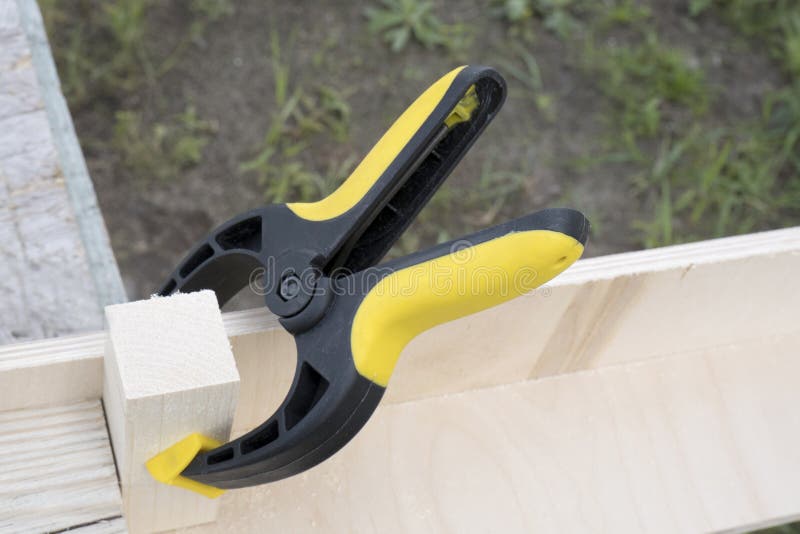 Clamp with plywood and a piece of pine wood. Construction, woodwork, carpentry concept royalty free stock photography Clamp with plywood and a piece of pine wood. Construction, woodwork, carpentry concept royalty free stock photography