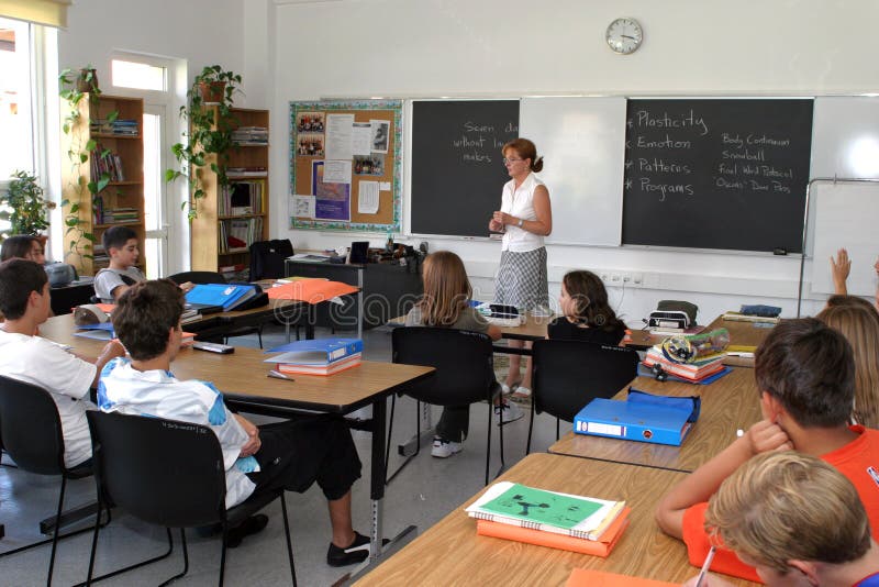 Teacher observes her high school class as they are taking a test. Teacher observes her high school class as they are taking a test.