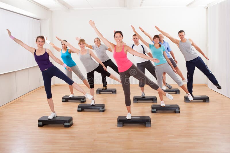 Class doing aerobics balancing on boards royalty free stock photos