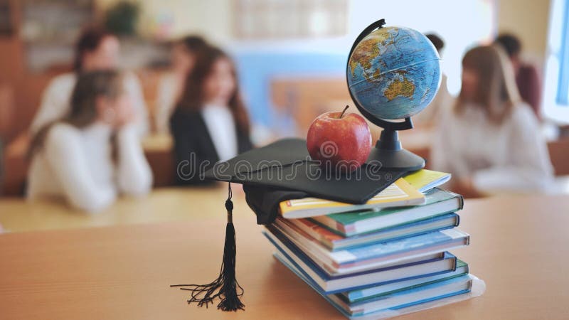 Class with students against background of books, apple, globe and graduation cap. stock photography