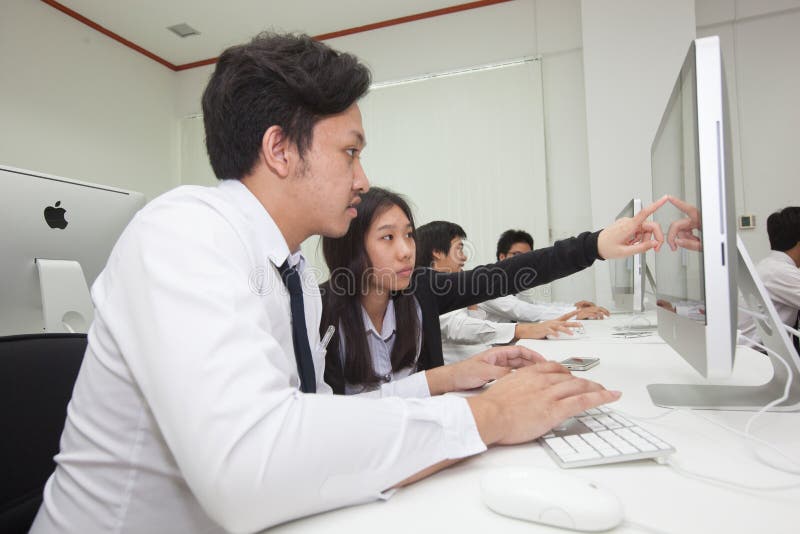 A class of students in front of their screens study computer science. stock images
