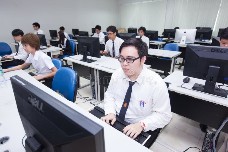 A class of students in front of their screens study computer science. stock photos