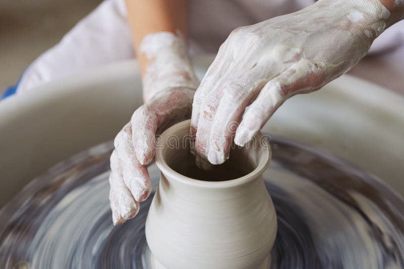 Hands of woman making clay jar during pottery class. Hands of woman making clay jar during pottery class