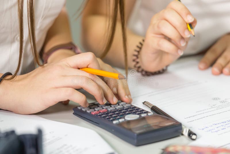 Math class, using the calculator, hands in frame. Math class, using the calculator, hands in frame