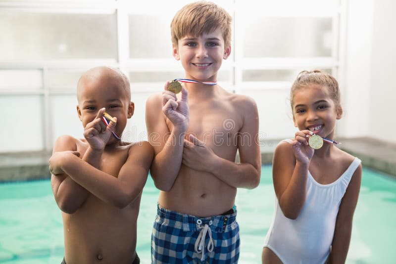 Classe mignonne de natation souriant avec des médailles images stock Classe mignonne de natation souriant avec des médailles images stock
