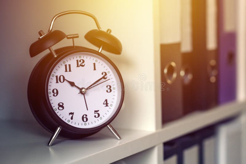 classic-alarm-clock-showing-time-during-working-hours-in-office-stock