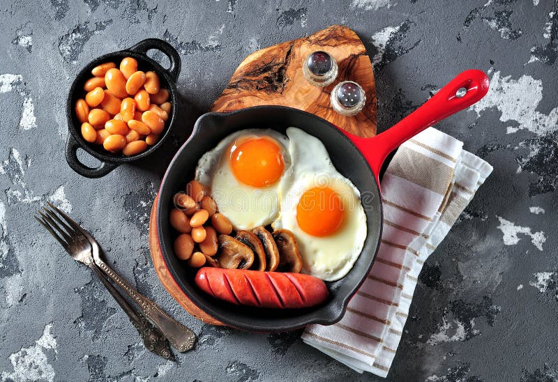 Classic Breakfast of Fried Eggs, Sausages, Mushrooms, Beans in a Cast ...