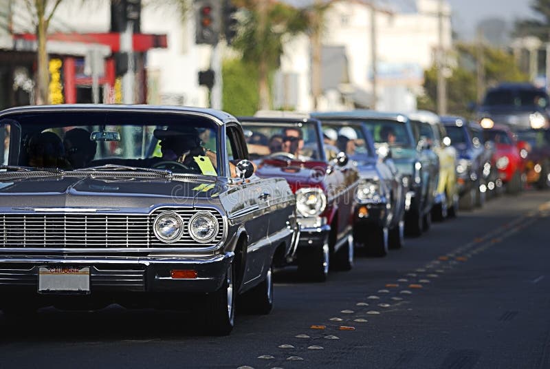 A line up of classic old cars cruising the local strip. A line up of classic old cars cruising the local strip.