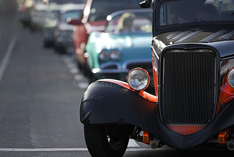 A line up of classic old cars cruising the local strip. A line up of classic old cars cruising the local strip.