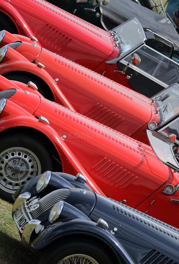 A group of classic cars lined up at a car show at Silverstone motor racing circuit. Silverstone Classic, July 2014. A group of classic cars lined up at a car show at Silverstone motor racing circuit. Silverstone Classic, July 2014.