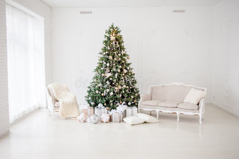 Classic christmas New Year decorated interior room New year tree. Christmas tree with gold decorations. Modern white classical sty