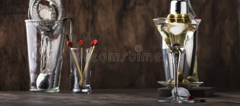 Classic Martini vodka cocktail, with dry vermouth, vodka and green olives, bar tools, vintage wood bar counter, selective focus stock photography Classic Martini vodka cocktail, with dry vermouth, vodka and green olives, bar tools, vintage wood bar counter, selective focus stock photography