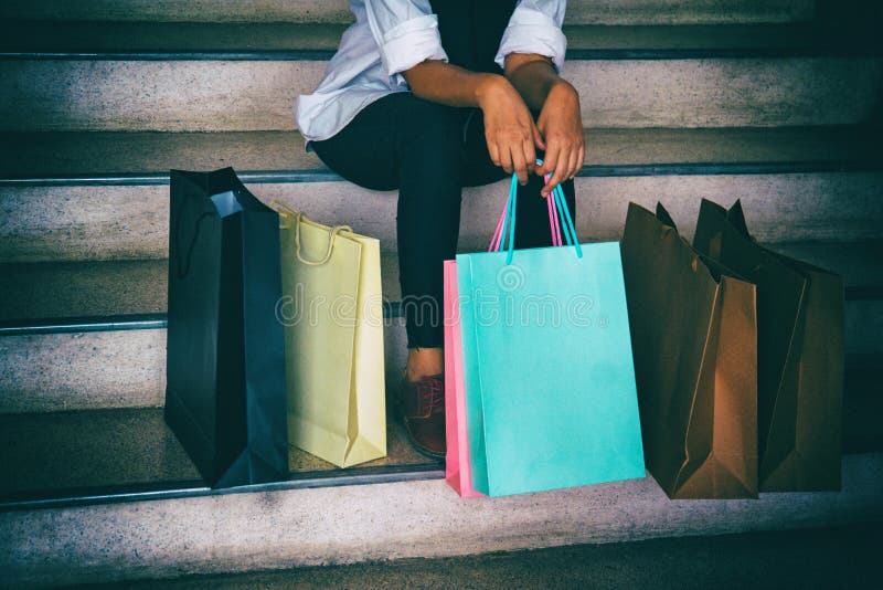 The classic old film design background of the lady is sitting on the stairs with colorful shopping bag,after shopping ,dramatic to royalty free stock photo The classic old film design background of the lady is sitting on the stairs with colorful shopping bag,after shopping ,dramatic to royalty free stock photo