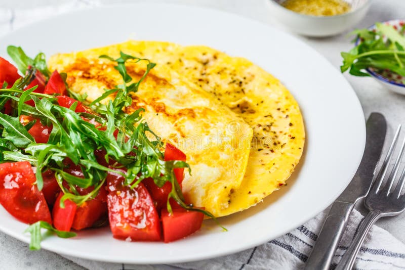 Classic Omelet with Cheese and Tomatoes Salad on White Plate, Top View ...