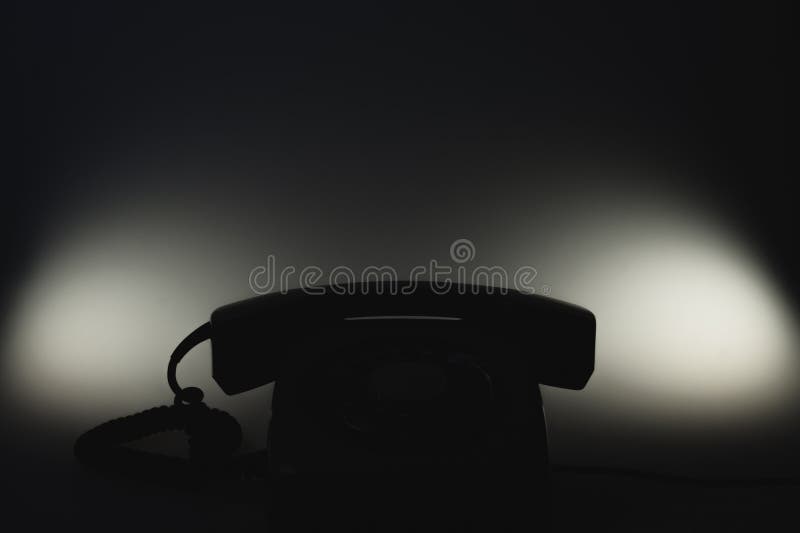 Classic phone silhouette in the dark. telephone with phone receiver. office background