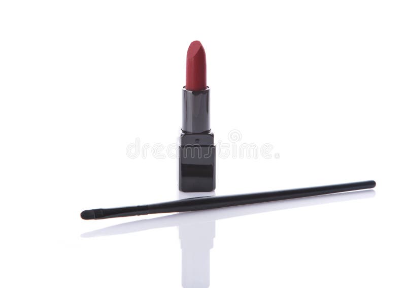 Classic red matte lipstick and make-up brush stock image