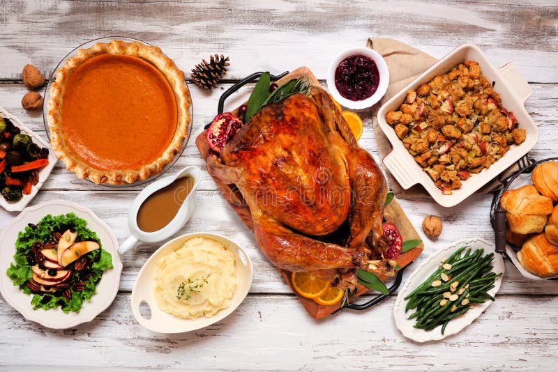 Classic Thanksgiving turkey dinner. Overhead view table scene on a rustic white wood background.