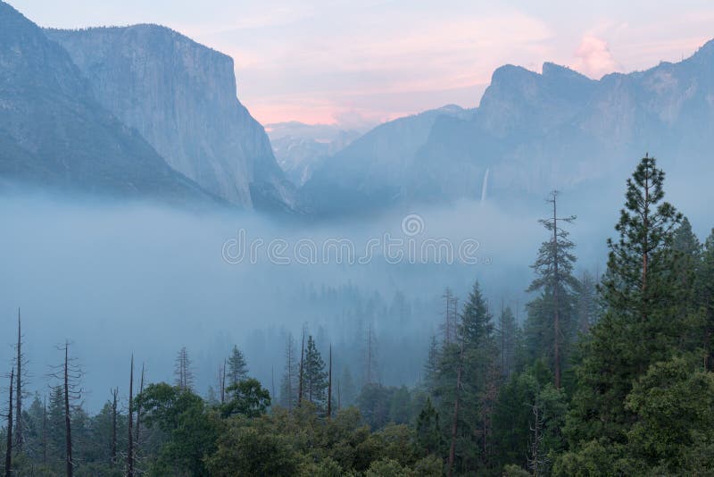 Classic Tunnel View of scenic Yosemite Valley with famous El Capitan and Half Dome rock climbing summits in beautiful atmosphere