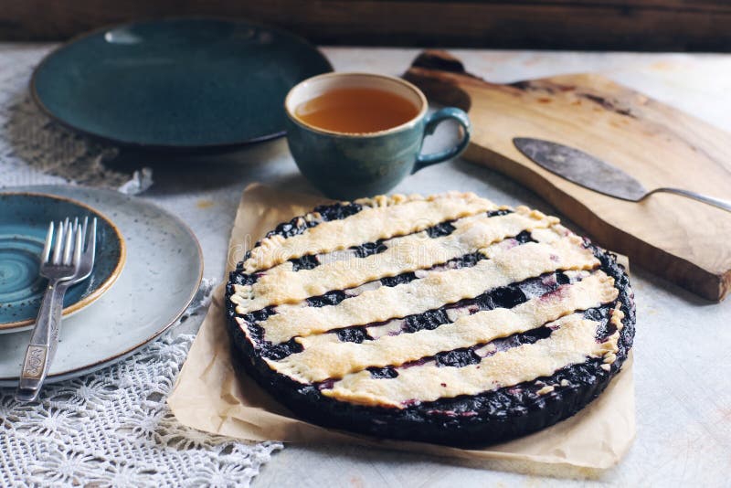 Classica torta di mirtilli fatta in casa su tovagliolo di lino. Classica torta di mirtilli fatta in casa sul tovagliolo di lino con tazza di tè sul rustico tavolo morbido