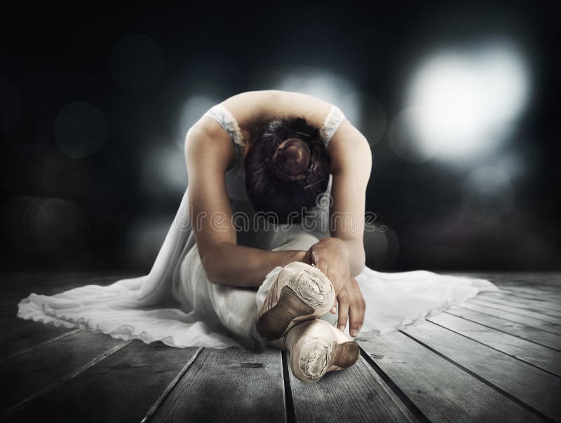 Classical dancer stretching on a stage of theater