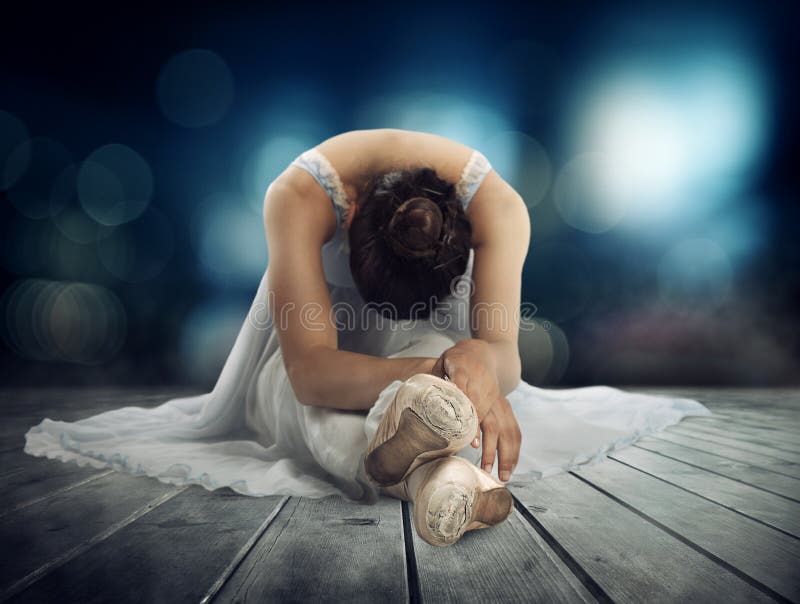 Classical dancer stretching on a stage of theater