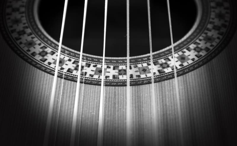 A black and white photo of a part of a classical guitar with the strings and the rosette. Abstract classical stock images, royalty-free photos and pictures