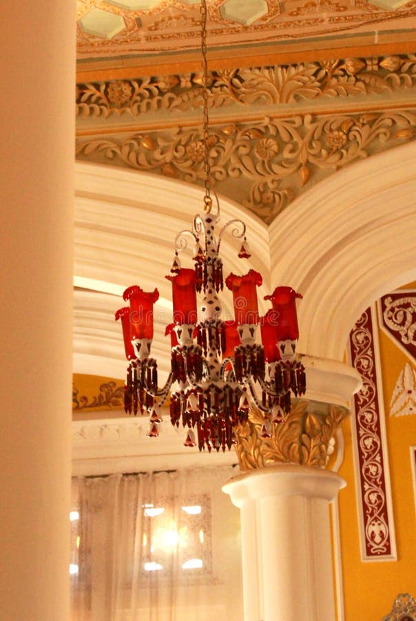 A classical red lamp set in the darbar hall of bangalore palace.