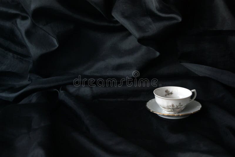 Classico e vintage di tè o caffè su fondo di satina nera testurizzata. Tazzine di tè o di caffè di vecchio stampo e d'epoca su fondo di satina nera testurizzata. teacup e dischi. esiste uno schema floreale. tempo di tè. tempo di caffè.
