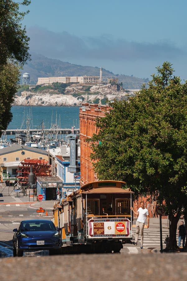 Classique san francisco street scène avec funiculaire yachts et île d'alcatraz. Funiculaire typique de san francisco sur une rue en pente près du front de mer avec yachts alcatraz enveloppé de brume. quai des pêcheurs touristiques vers le nord-est.