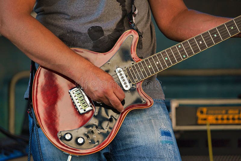 Clausura de un músico tocando una guitarra eléctrica especial roja en un estudio