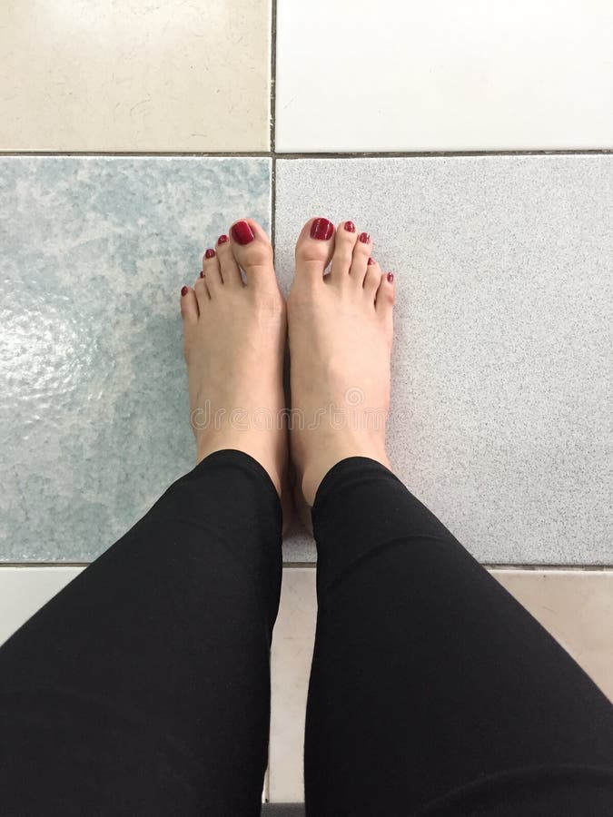 Clavo rojo al aire libre de los pies desnudos de Selfie en fondo del piso imágenes de archivo libres de regalías Clavo rojo al aire libre de los pies desnudos de Selfie en fondo del piso imágenes de archivo libres de regalías