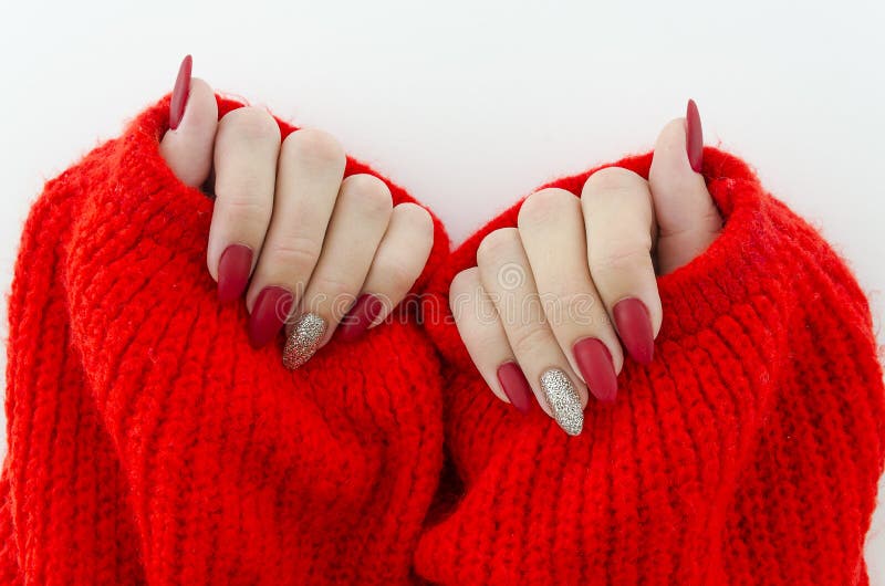 Clavos femeninos hermosos del finger con cierre rojo del clavo para arriba en el suéter hecho punto rojo Manicura perfecta fotos de archivo libres de regalías Clavos femeninos hermosos del finger con cierre rojo del clavo para arriba en el suéter hecho punto rojo Manicura perfecta fotos de archivo libres de regalías