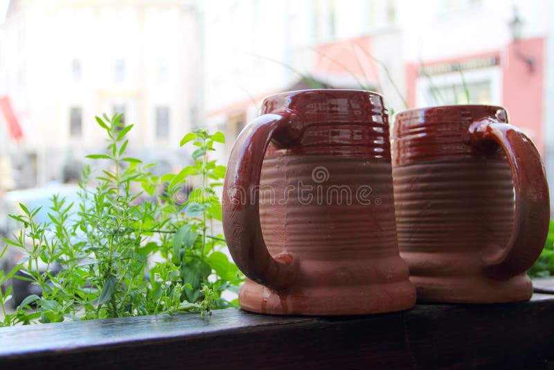 Two traditional clay beeg mugs on wooden table in cafe. Two traditional clay beeg mugs on wooden table in cafe