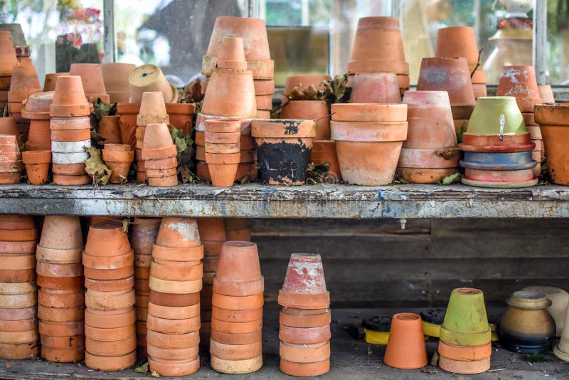 Two shelves filled with clay flower pots of various sizes and colors. Two shelves filled with clay flower pots of various sizes and colors.