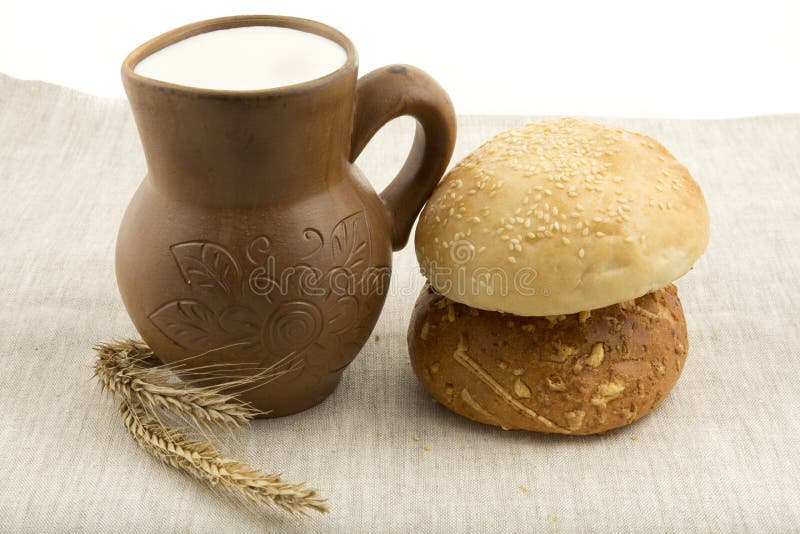 Clay jug with milk and bread stock images