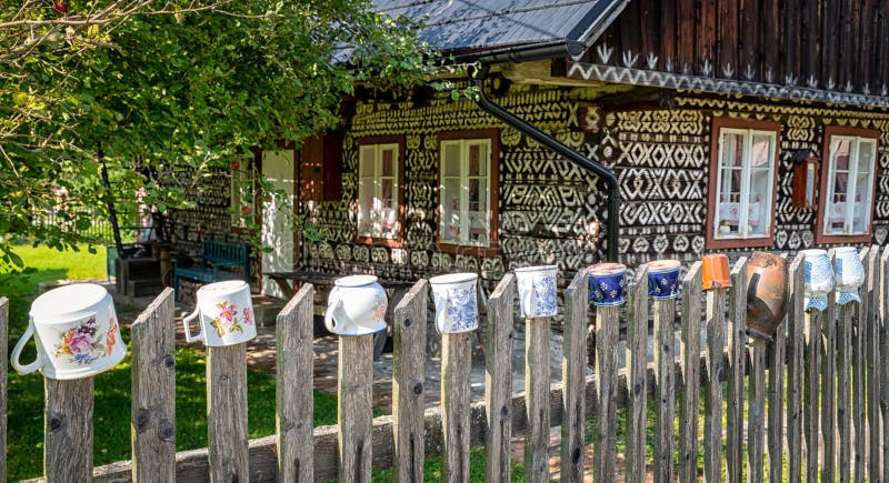 Clay jugs on fence in front of old wooden house in village Cicmany