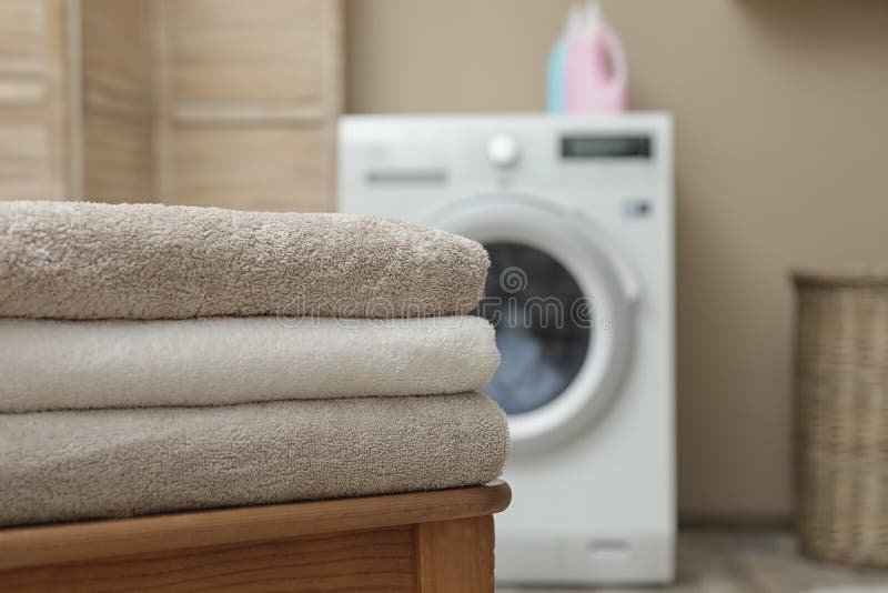 Clean Folded Towels on Table in Laundry Room, Space for Text Stock