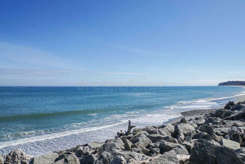 Sea wave and breeze at rock shore in New Zealand with bright blue sky