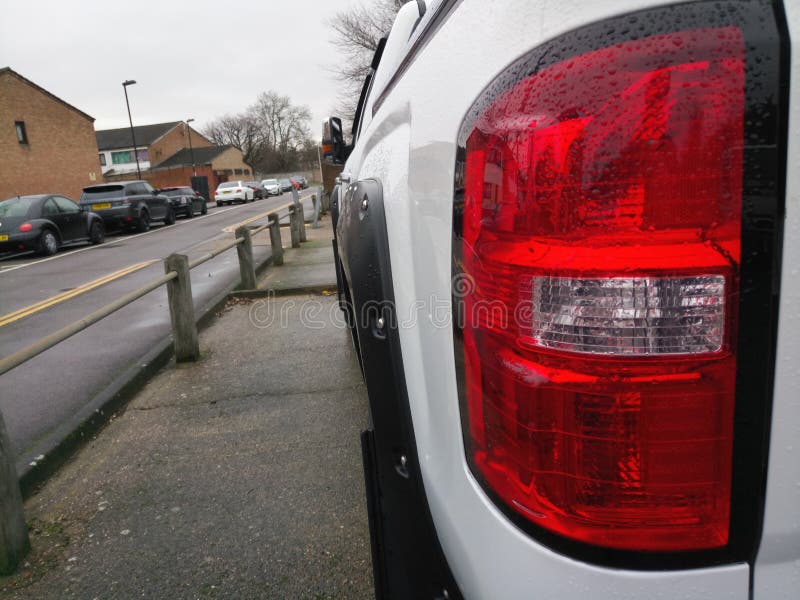 Perspective View of a Red Brake Light on a White Car Stock Image