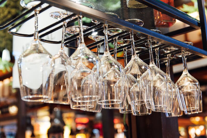 Clean Wine Glasses Hanging Upside Down Above a Bar Rack in Restaurant