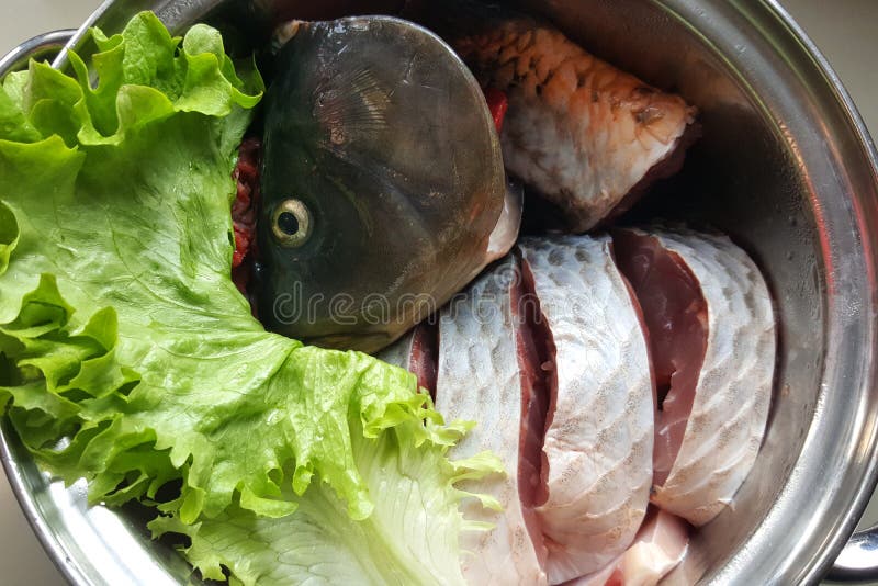 Cleaned Fish Carp in a Dish on the Kitchen Table Decorated with Lettuce