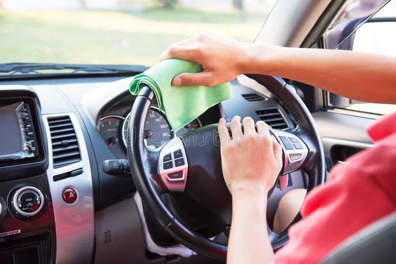 Cleaning the car interior with green microfiber cloth