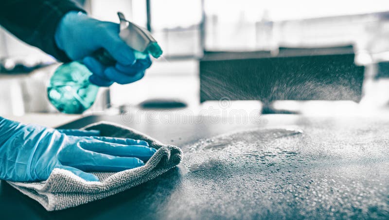 Cleaning home table sanitizing kitchen table surface with disinfectant spray bottle washing surfaces with towel and. Gloves. COVID-19 prevention sanitizing stock photo