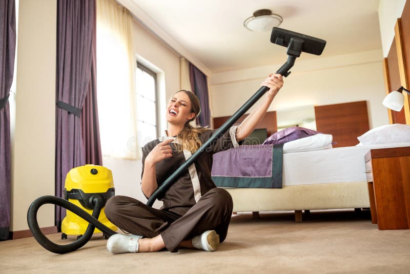 Cleaning lady fooling around with the vacuum cleaner